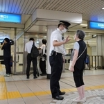 車両故障による運転見合わせを乗客に説明する阪神電鉄の社員＝２４日午後９時２１分、阪神春日野道駅