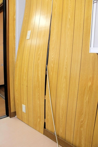 正面玄関を突き破った車が衝突した待合室の壁は裏側も大きくゆがんでいた＝24日午後６時２７分、丹波篠山市黒岡