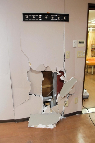 正面玄関を突き破った車が衝突した整骨院の待合室の壁＝24日午後６時１６分、丹波篠山市黒岡