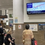 運転見合わせとなり、電光掲示板を見つめる利用客ら＝８日午前９時３２分、ＪＲ神戸駅