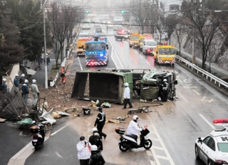横転し、車道をふさぐトラック＝２１日午後１時４８分、神戸市灘区鶴甲５
