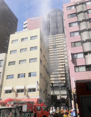 白煙を上げるビル。ＪＲ，阪神元町駅北側の繁華街の一角で一時騒然とした＝11日午後１時５４分、神戸市中央区下山手通３