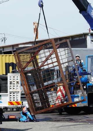 現場から回収される鉄製のラック。トラックから落下し、男性が下敷きになったとみられる＝１１日午前１０時１２分、神戸市中央区港島９