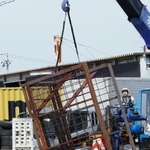 現場から回収される鉄製のラック。トラックから落下し、男性が下敷きになったとみられる＝１１日午前１０時１２分、神戸市中央区港島９