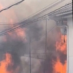 窓から炎と煙を上げて燃える長屋＝２０日午後、兵庫県尼崎市瓦宮１（読者提供）