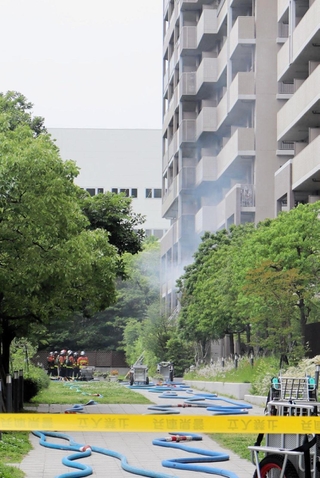 白煙が上がるマンション＝20日午後、神戸市東灘区向洋町