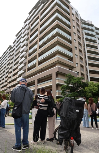 火災があったマンション付近で避難した住民らが肩を寄せた＝２０日午後１時６分、神戸市東灘区向洋町中５