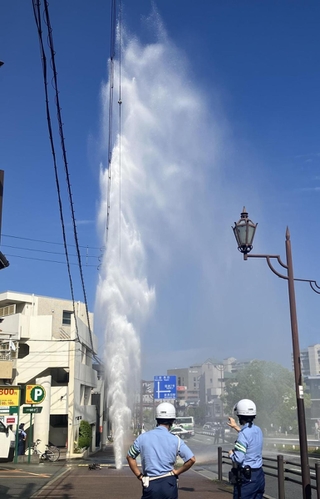 消火栓から空高く吹き出す水＝２１日午後３時７分、神戸市長田区山下町４