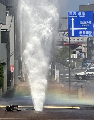 消火栓から空高く吹き出す水。虹も出現した＝２１日午後３時８分、神戸市長田区山下町４