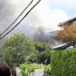 煙を上げて燃える民家＝８日午前１１時１６分、川西市向陽台２