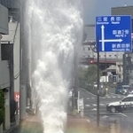 消火栓から空高く吹き出す水。虹も出現した＝２１日午後３時８分、神戸市長田区山下町４
