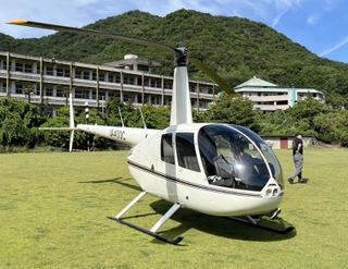 相生学院高校のグラウンドに緊急着陸したヘリコプター＝１０日午後４時ごろ、相生市野瀬（同校提供）