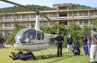グラウンドに緊急着陸したヘリコプターを調べる航空事故調査官ら＝１１日午後３時１分、相生市野瀬、相生学院高校（撮影・辰巳直之）