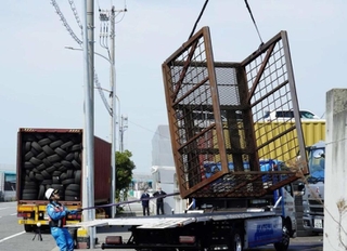 現場から撤去される、トラックから落下した鉄製のラック（右端）＝４月１１日午前１０時１５分、神戸市中央区港島９