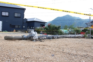 根元から折れて倒れた電柱＝市川町西川辺