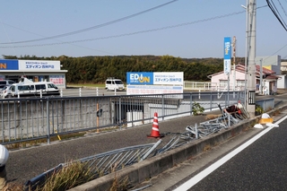 軽乗用車が横転した現場。衝撃でフェンスが破損している＝２２日午前１１時４７分、神戸市西区平野町宮前