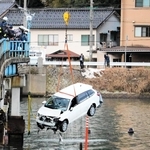 川の中から引き揚げられる乗用車＝豊岡市城崎町今津