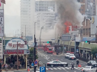 商店街の一画で炎を上げて燃える建物＝１２日午後０時半、明石市本町１