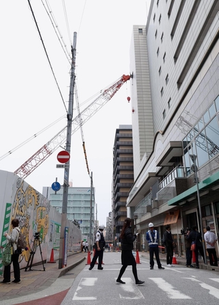 隣接する建物に接触しクレーン＝１０日午後４時１６分、神戸市中央区旭通５（撮影・丸山桃奈）