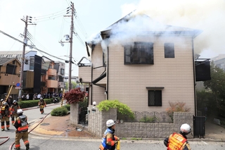 ２階から煙が上がる民家＝１９日午前１１時１６分、西宮市屋敷町