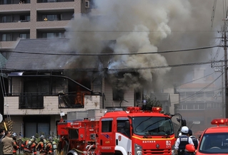 ２階から黒煙が上がる民家。時折赤い炎が見えた＝１９日午前１１時２７分、西宮市屋敷町