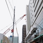 隣接する建物に接触しクレーン＝１０日午後４時１６分、神戸市中央区旭通５（撮影・丸山桃奈）