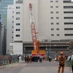 クレーンが建物にぶつかった工事現場＝１０日午後４時１３分、神戸市中央区雲井通５