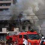 ２階から黒煙が上がる民家。時折赤い炎が見えた＝１９日午前１１時２７分、西宮市屋敷町