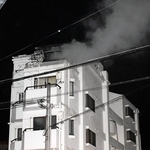 煙を上げるマンション＝27日午後10時47分、神戸市垂水区清水が丘３