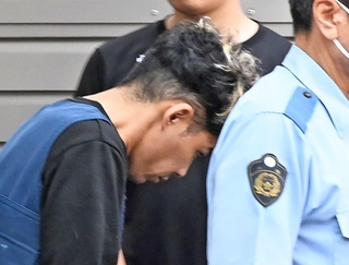 捜査員に連れられて警察車両に乗り込む谷本将志容疑者＝２４日午前９時２３分、神戸市中央区吾妻通５