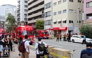 ビルの一室から黒煙が上がり騒然とする現場＝１４日午後３時１７分、神戸市中央区下山手通３