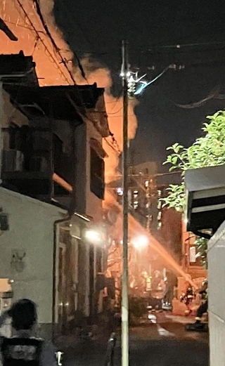 火の粉を上げて燃える民家＝６日午後１０時４４分、神戸市垂水区五色山２