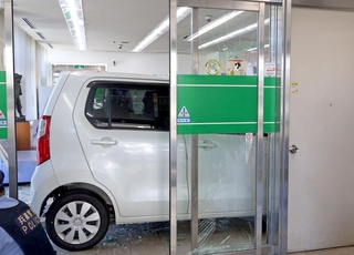ガラスを突き破り、金融機関の店内まで突っ込んだ軽乗用車＝１５日午後、加古川市神野町西条