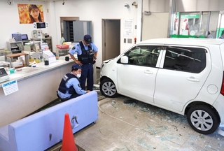 ガラスを突き破り、金融機関の店内まで突っ込んだ軽乗用車＝１５日午後、加古川市神野町西条