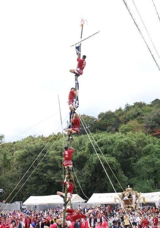 竹によじ登る人たち＝高砂市阿弥陀町生石
