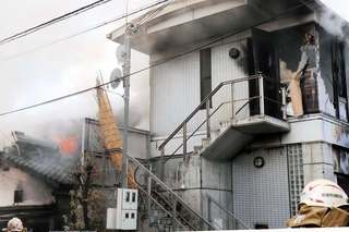火の手が上がる民家（左）＝２０日午前８時２４分、姫路市北条宮の町