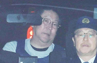 警察車両で送致される立花孝志容疑者（左）＝１０日午前９時４１分、神戸市中央区下山手通５