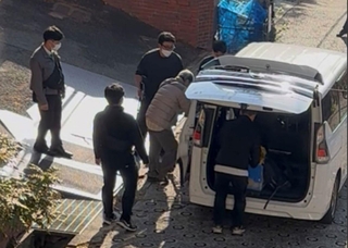 社長の男を任意同行する捜査員ら＝２６日午前８時半ごろ、神戸市中央区