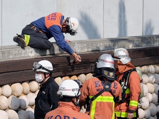 現場付近を調べる消防隊員＝１３日午後０時９分、神戸市中央区東川崎町１