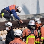 現場付近を調べる消防隊員＝１３日午後０時９分、神戸市中央区東川崎町１