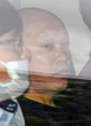 捜査車両に乗せられて長田署を出る菱川龍己容疑者＝２４日午前９時４０分、神戸市長田区北町３