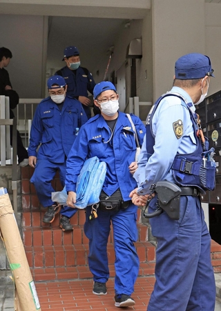 現場マンションから出てくる捜査員ら＝２１日午後５時７分、神戸市中央区中山手通６