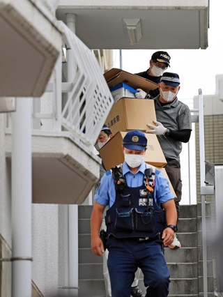 遺体が見つかったマンションから出てくる捜査員ら＝２１日午後５時１６分、神戸市中央区中山手通６