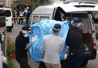 遺体が見つかった部屋から押収物を運び出す捜査員ら＝２２日午後５時３３分、神戸市中央区中山手通６