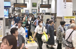 火災の影響で運転見合わせとなり、改札を出る乗客＝２２日午前１１時１４分、神戸市中央区、ＪＲ神戸駅