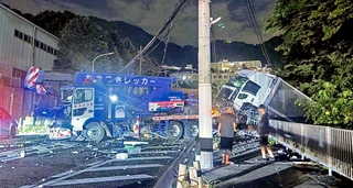 信号柱などに衝突する事故を起こしたレッカー車。周辺にはけん引していたトラックの積み荷が散乱した＝２０日夜、神戸市灘区一王山町（読者提供）