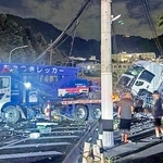 信号柱などに衝突する事故を起こしたレッカー車。周辺にはけん引していたトラックの積み荷が散乱した＝２０日夜、神戸市灘区一王山町（読者提供）