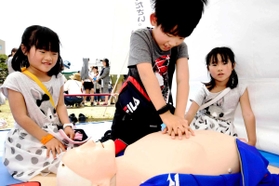 イベントで心臓マッサージを体験する子どもたち＝昨年５月、三田市