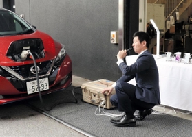 電気自動車からの給電作業にあたる神戸酒心館の社員＝神戸市東灘区御影塚町１