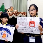 ボーイスカウトの仲間たちに防災の大切さを説明する防災士の酒井牡丹さん（右）＝神戸市東灘区